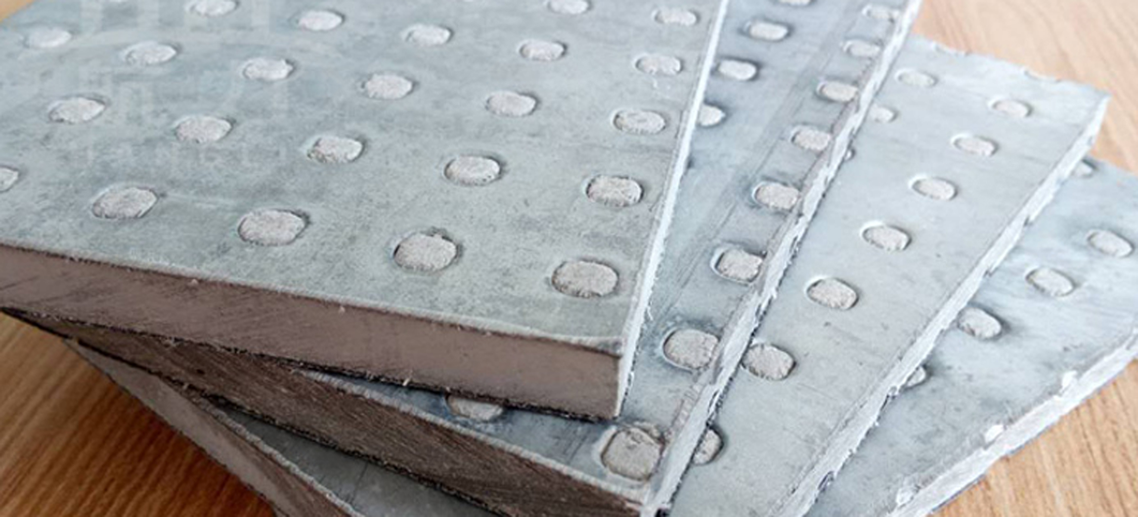 纖維水泥抗爆板又稱防爆板是為存在潛在爆炸危險區(qū)域、防震等特殊工作系統要求提供解決方案而研發(fā)生產的一種特殊板材，它是由增強纖維水泥板表面加壓鍍鋅鋼材料所構成，具有良好的抗爆及阻燃效果。由于板材內部特殊的構造可以有效減輕爆炸的沖擊，耐久性高，九德增強纖維水泥抗爆板依據專門爆破檢測機構的嚴格檢測，單板抗爆能力高達1.6MPa，抗爆墻抗爆能力高達2.0MPa，遠高于國家相關標準規(guī)定的墻體抗爆1.4Mpa。